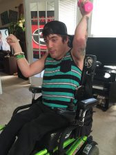 Man using a wheelchair exercises with a weight 