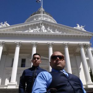 Two people standing in front of the capitol building