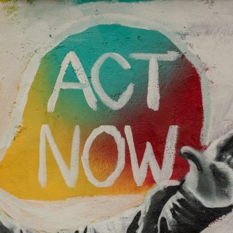 Act now painted on a wall